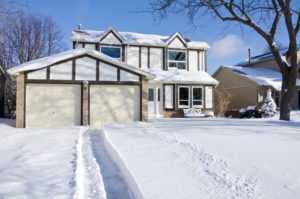 house and driveway covered with snow