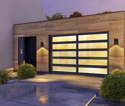 Contemporary wood‑clad garage with black aluminum full‑view glass door at dusk